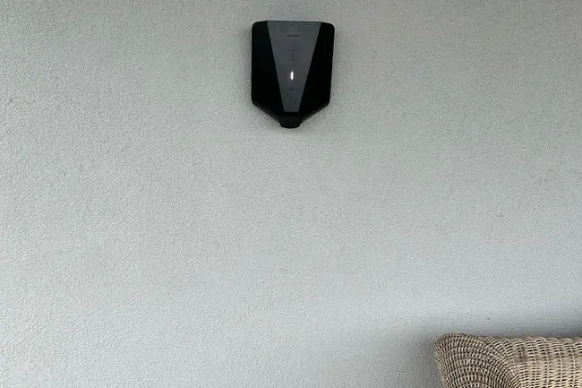 Zwarte Easee-lader hoog aan een minimalistische witte buitenmuur, geplaatst door Laadnatie.