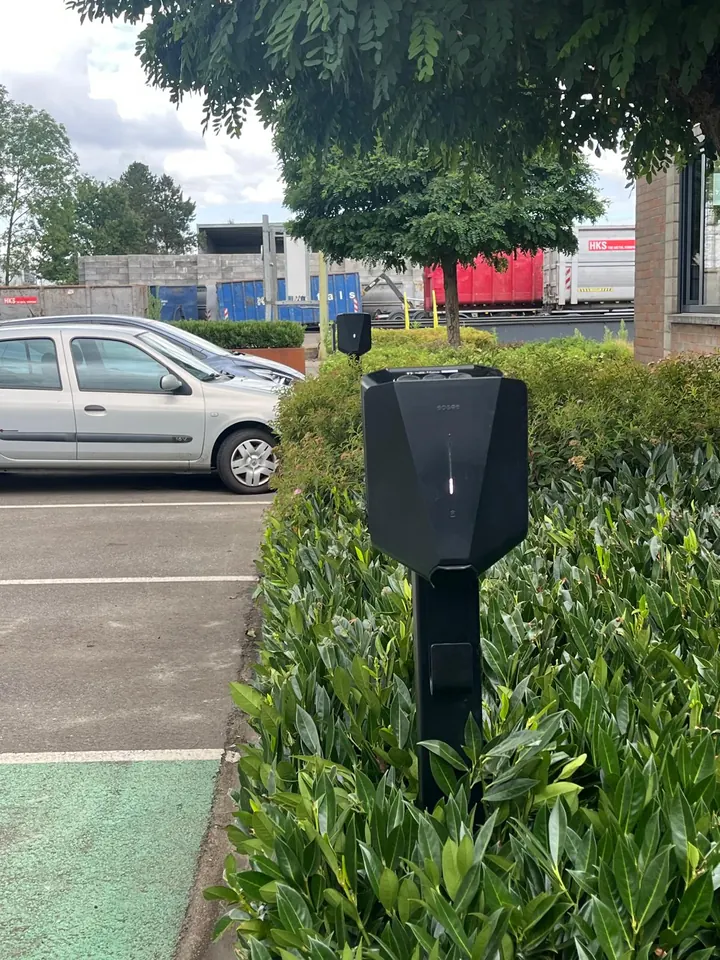 Twee zwarte Easee-laders op montagepalen tussen het groen bij een bedrijfsparking, geplaatst door Laadnatie.
