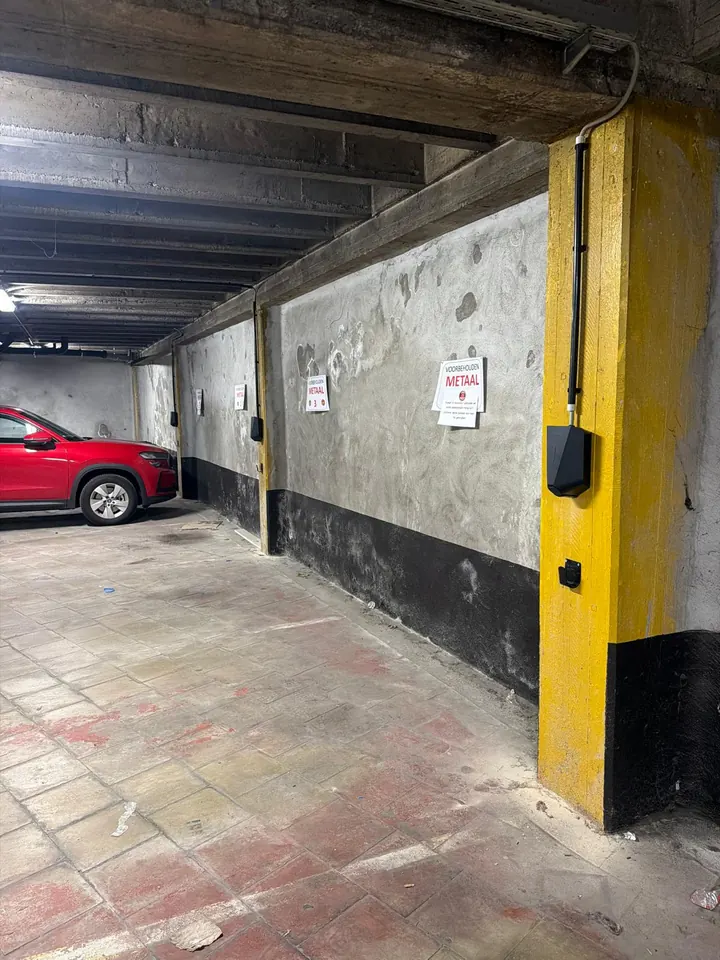 Meerdere zwarte Easee-laders aan de kolommen van een industriële parking, geplaatst door Laadnatie.